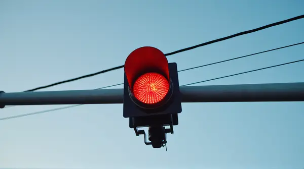 Red Traffic Signal On Metal Pole With Clear Sky