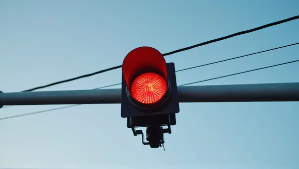 Red Traffic Signal On Metal Pole With Clear Sky