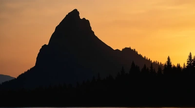 Rocky Peak Silhouette With Amber Sky Background