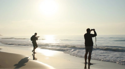 Silhouetted Figures Along Ocean Shoreline Horizon