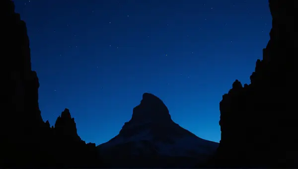 Silhouetted Rugged Peak Against Indigo Sky