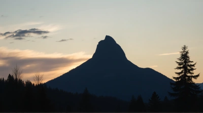 Silhouetted Summit Against Fading Sky With Trees