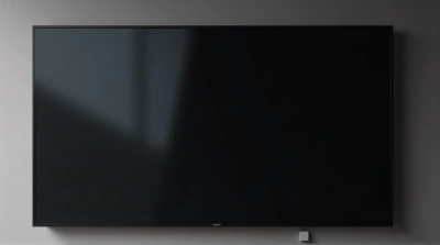 Sleek Dark Television On Smooth Wall With Reflections