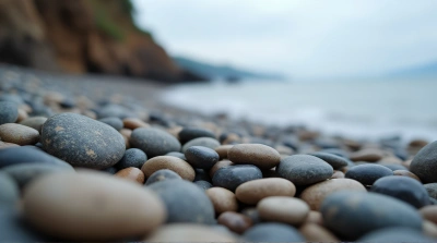 Smooth Pebbles On Rugged Beach Edge In Soft Light