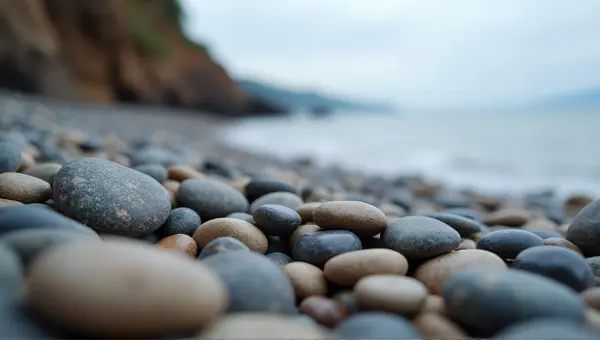 Smooth Pebbles On Rugged Beach Edge In Soft Light