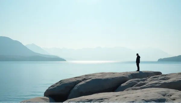 Solitary Figure On Textured Gray Stone By Lake