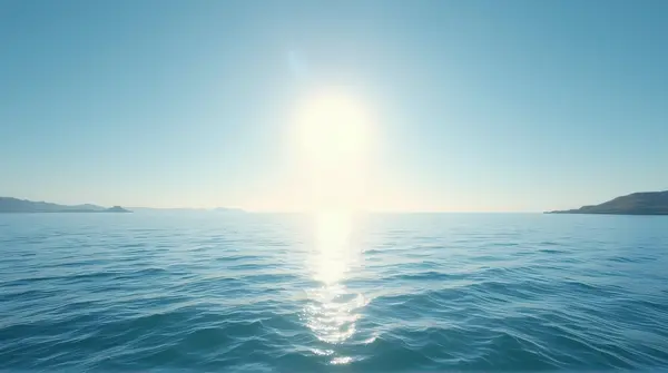 Sunlight shining on ocean waves stretching toward a distant horizon under an open sky.