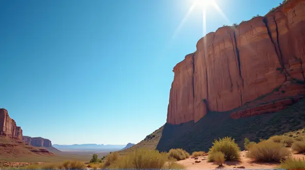 Sunlit Rugged Cliff Face Against Clear Blue Sky