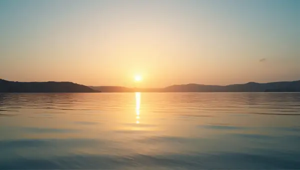 Sunset Over Tranquil Water With Rolling Hills