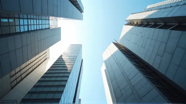Bird’s-eye view of tall gray towers in sunlight with clear blue sky above