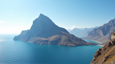 Tall Mountain Peak Next To Large Water Body Under Clear Sky
