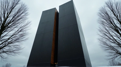 Tall Textured Tower With Bare Trees Under Overcast Sky