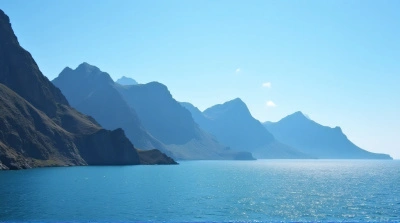 Towering Peaks Over Shimmering Water Under Clear Sky