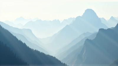 Towering Peaks Shrouded In Mist Under Pale Sky