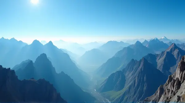 Wide-angle view of tall peaks with sunlight creating shadows under a bright blue sky