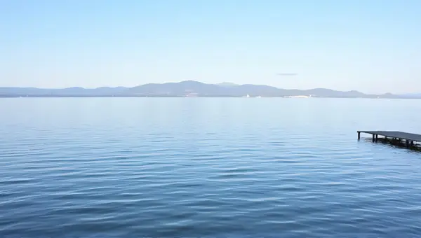 Tranquil Lake Scene With Wooden Pier And Hills