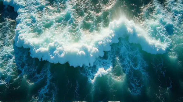 Aerial view showing intricate patterns of swirling sea currents and whitecaps under soft sunlight