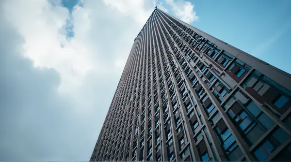 Low angle view of a detailed facade with complex patterns under a partly cloudy sky.