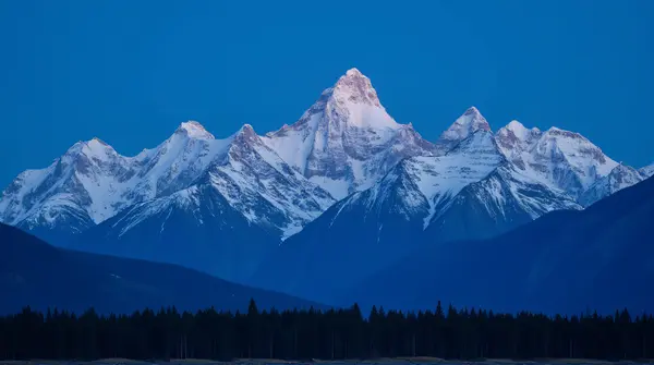 White-Capped Peaks Against Blue Twilight Sky