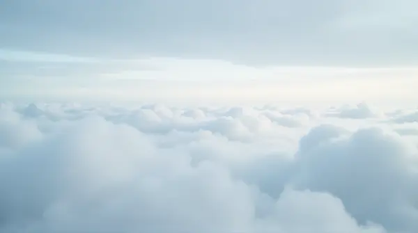 Low-angle view of a wide sky filled with soft, silvery layered cloud formations spreading evenly.