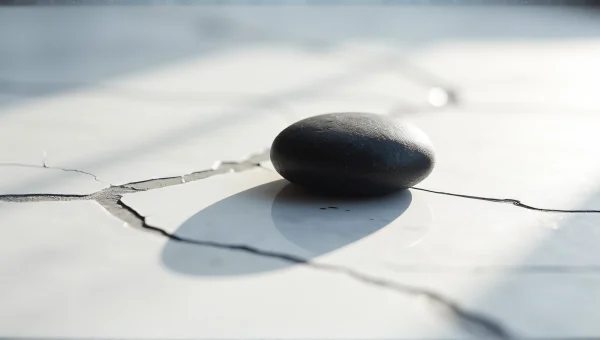 Black Stone On Cracked White Marble Surface