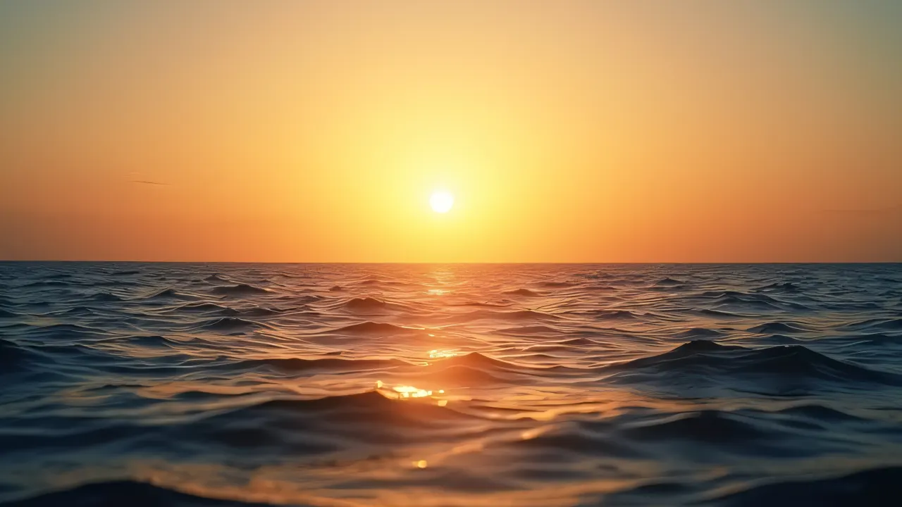 Wide view of ocean waves during golden hour with warm sunlight reflections and gentle breeze.