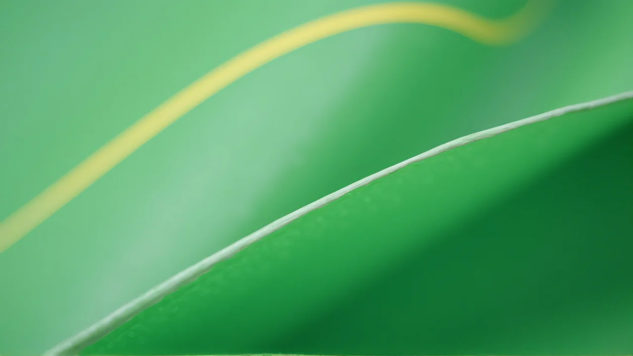 Close-up macro shot of a green surface with white and yellow lines.
