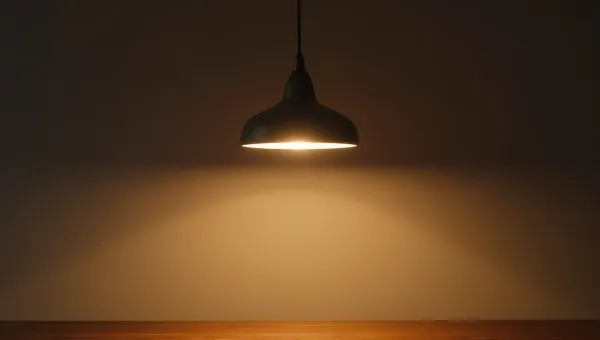 Illuminated Pendant Lamp Above Wooden Table