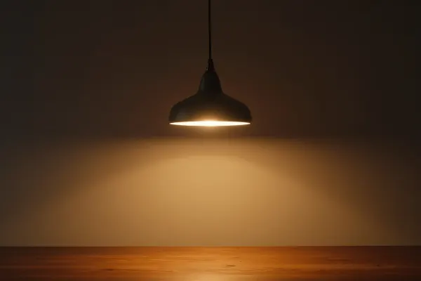 Illuminated Pendant Lamp Above Wooden Table