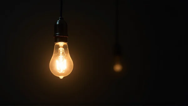 Incandescent Light Bulb Glow Against Dark Background