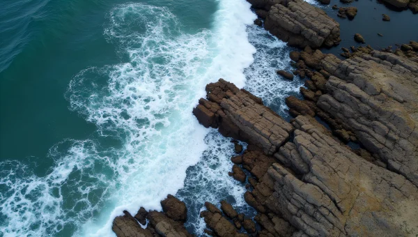 Jagged Rocky Shore With Turbulent Surf Aerial View