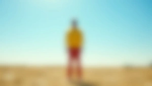Lone Man In Yellow Shirt On Sunlit Plain