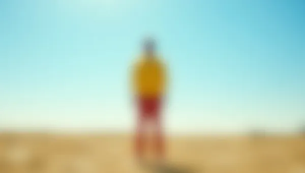 Lone Man In Yellow Shirt On Sunlit Plain