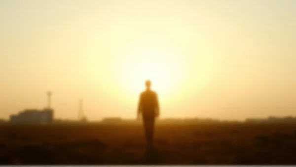 Lone Person Silhouette In Open Field Under Sky