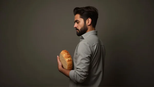 Man Holding Fresh Loaf of Bread in Studio Light