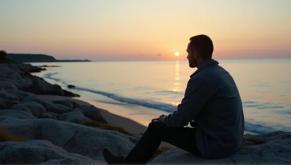 Man Seated on Rocky Shoreline at Dusk