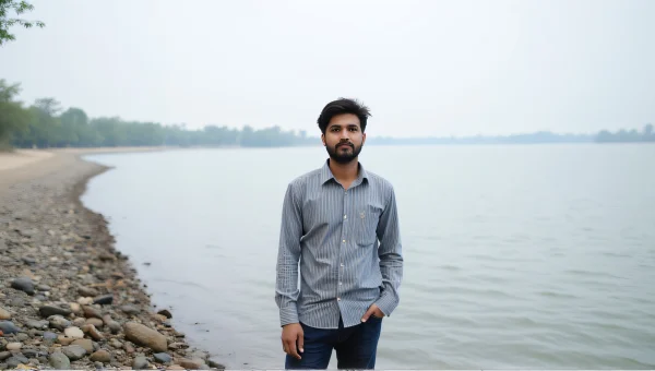 Man Standing By Calm Lake Shoreline Striped Shirt