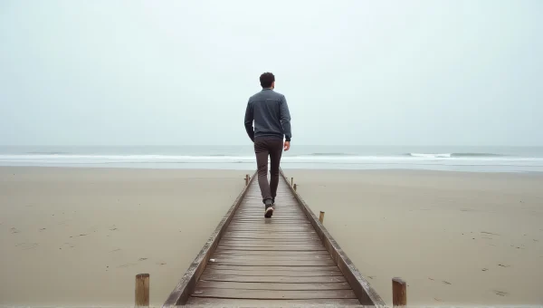 Man Walking on Weathered Dock by Quiet Beach
