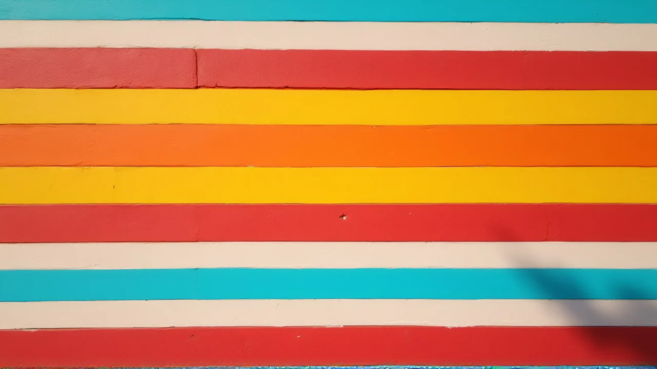 A wide shot of a colorful striped wall with soft side lighting and shadows.