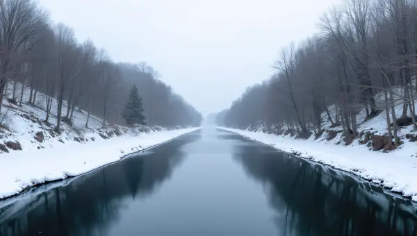 Narrow River Through Snowy Valley With Trees