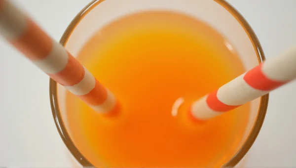 Orange Drink Filling Champagne Flute With Straws