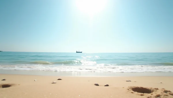 Sandy Shoreline With Calm Ocean And Sailboat
