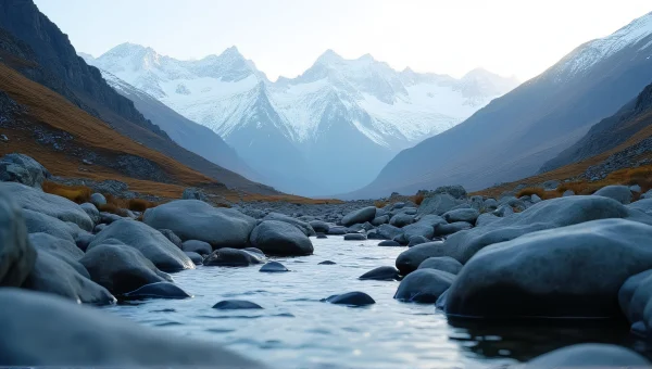 Snow-Capped Mountains Behind Clear Stream Landscape