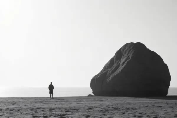 Solitary Man by Weathered Rock on Shoreline