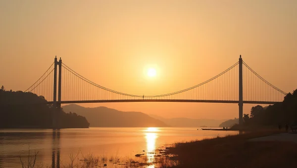 Suspension Bridge Silhouette Over Calm River