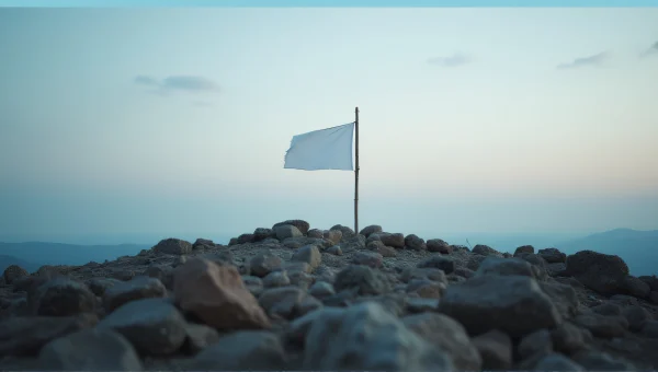 White Flag Waving On Rocky Hill At Dusk