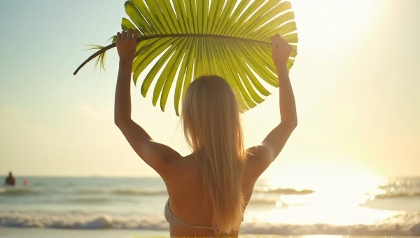 Woman Holding Palm Leaf On Sunlit Shoreline