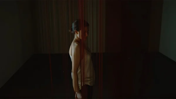 Woman Portrait With Red Strings In Dim Room