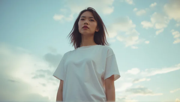 Woman Posing in White T-Shirt Under Dramatic Sky